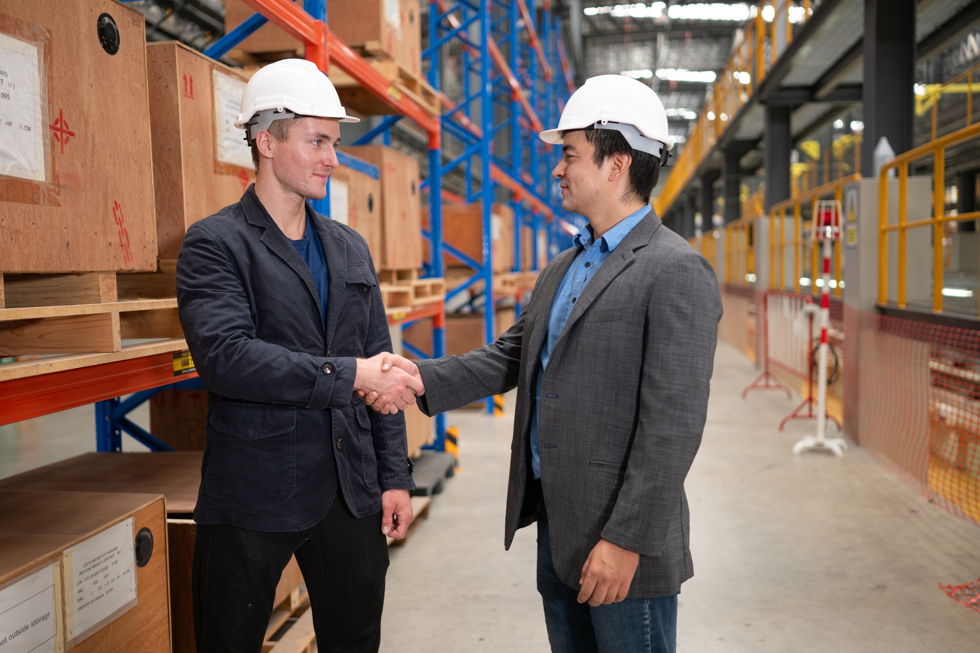 Two businessmen shaking hands in a warehouse It is a warehouse of spare parts and equipment